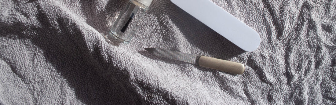 Outils de manucure posés sur une serviette blanche, kit de base pour débuter