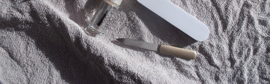 Outils de manucure posés sur une serviette blanche, kit de base pour débuter